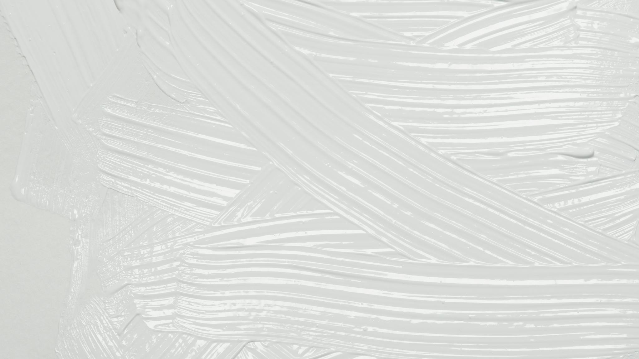 Close-up of white paint texture with brushstrokes creating an artistic background.