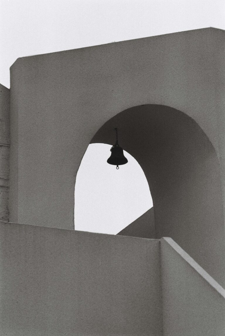 Minimalist black and white photo of a bell tower with geometric shapes.